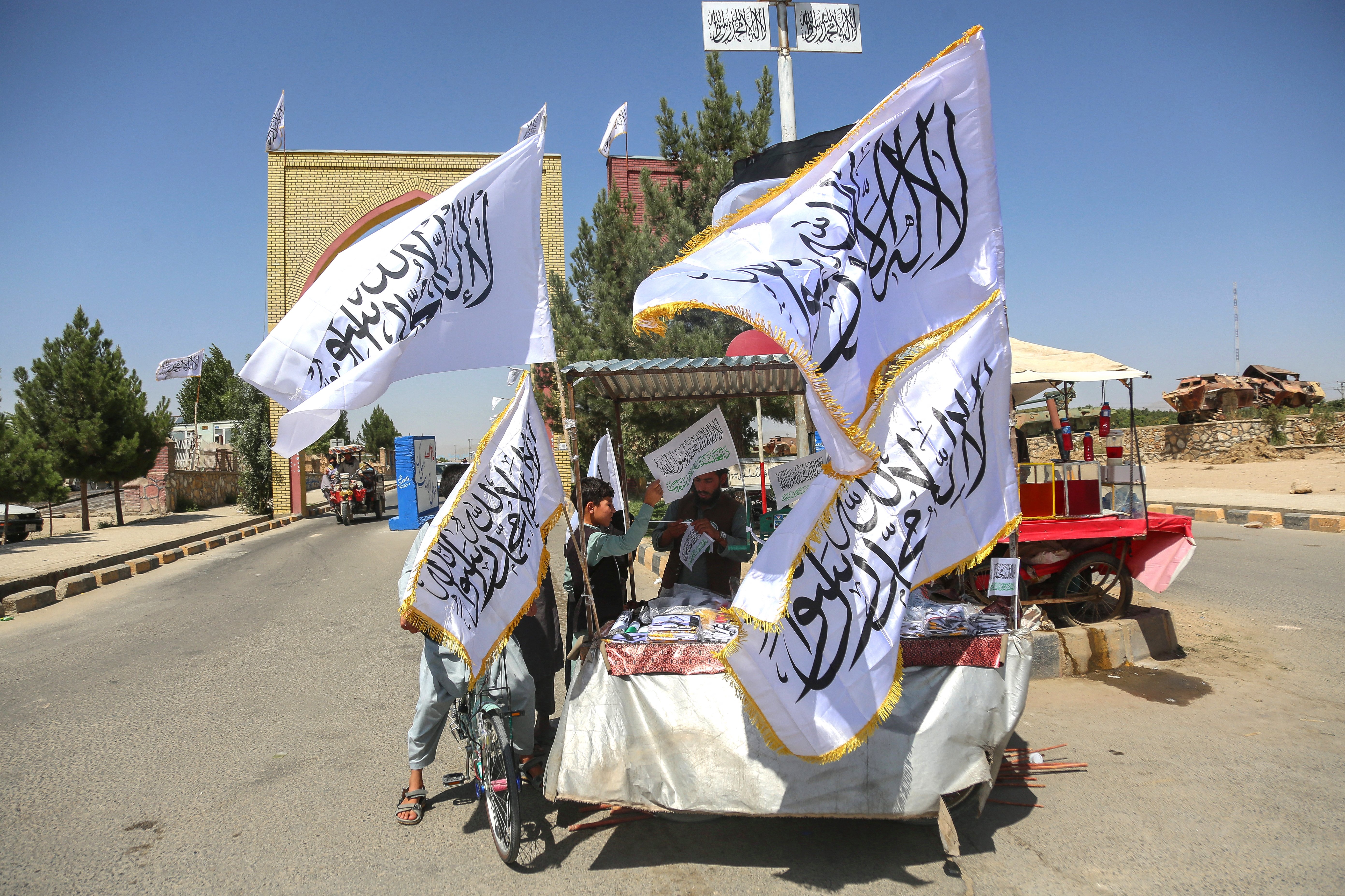 Taliban supporters display white flags bearing the Shahada inscription on a cart in an Afghan street on the fifth anniversary of Taliban rule