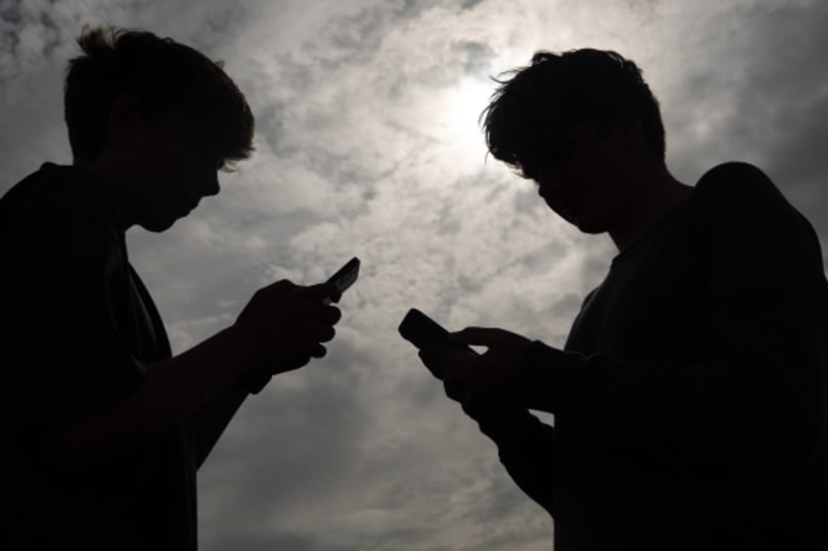 Teenagers using smartphones, illustrating social media addiction lawsuits cleared by the Ninth Circuit
