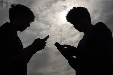 Teenagers using smartphones, illustrating social media addiction lawsuits cleared by the Ninth Circuit