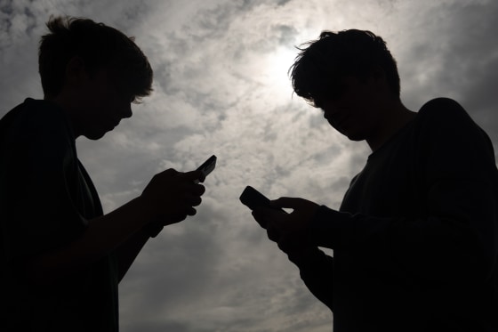 Teenagers using smartphones, illustrating social media addiction lawsuits cleared by the Ninth Circuit