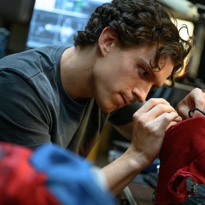 Tom Holland as Peter Parker repairing his suit in Spider-Man Brand New Day