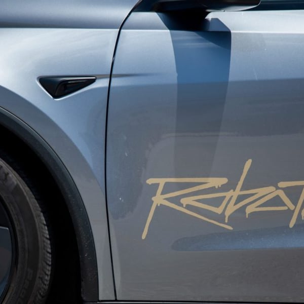 TSLA stock today: the Robotaxi wordmark on the flank of a Tesla, the marking Nevada regulators require on approved autonomous vehicles