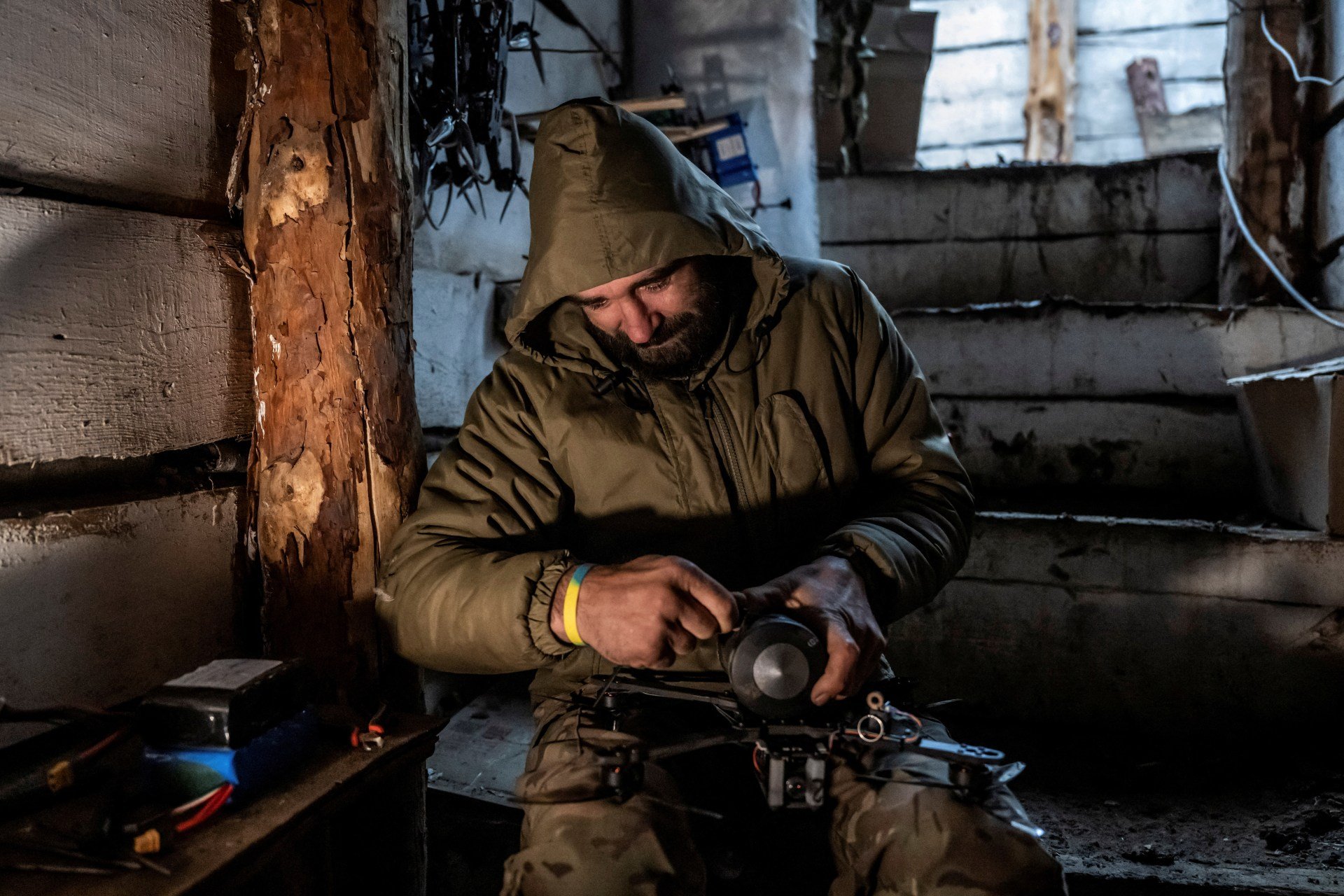 Ukrainian serviceman attaching a shell to a first-person-view drone in a dugout