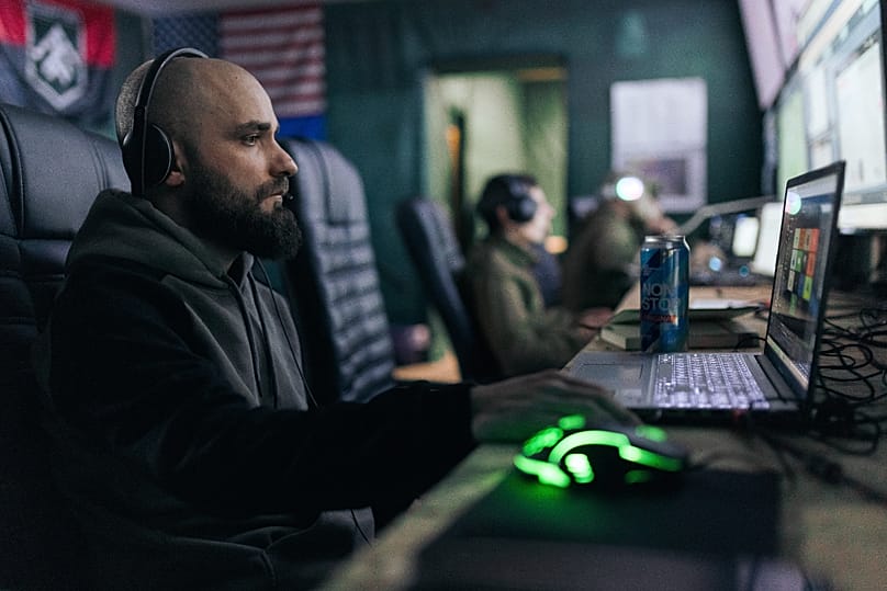 Ukrainian soldiers operating drones from laptops at a command post in the Kharkiv region