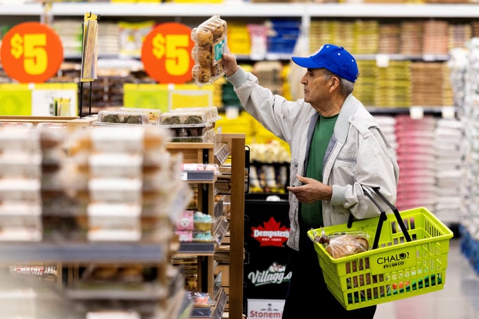 A customer reaches for a product in a grocery store as US consumer prices hold elevated at 3.7 percent annually in June 2026