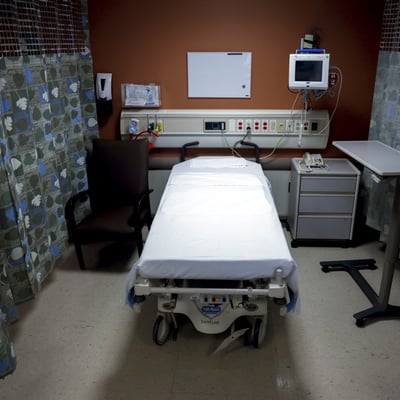 An empty hospital bed in a US hospital room as employer health insurance costs rise