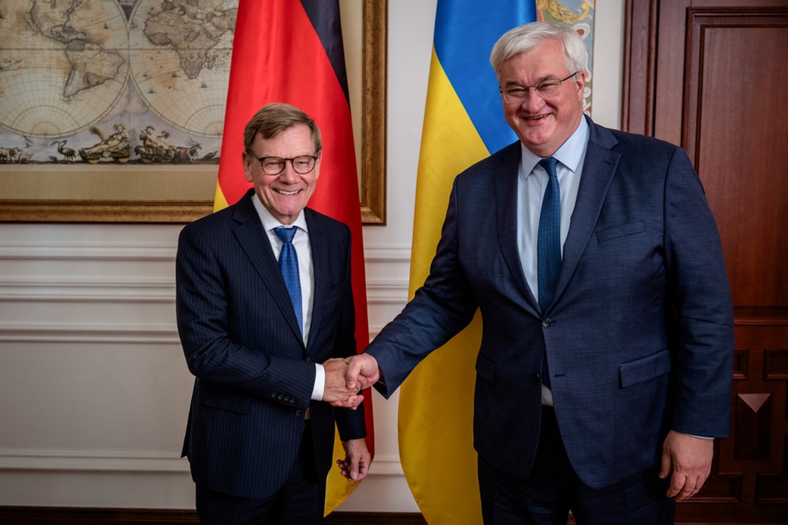 German Foreign Minister Johann Wadephul shakes hands with Ukrainian Foreign Minister Andrii Sybiha in front of German and Ukrainian flags