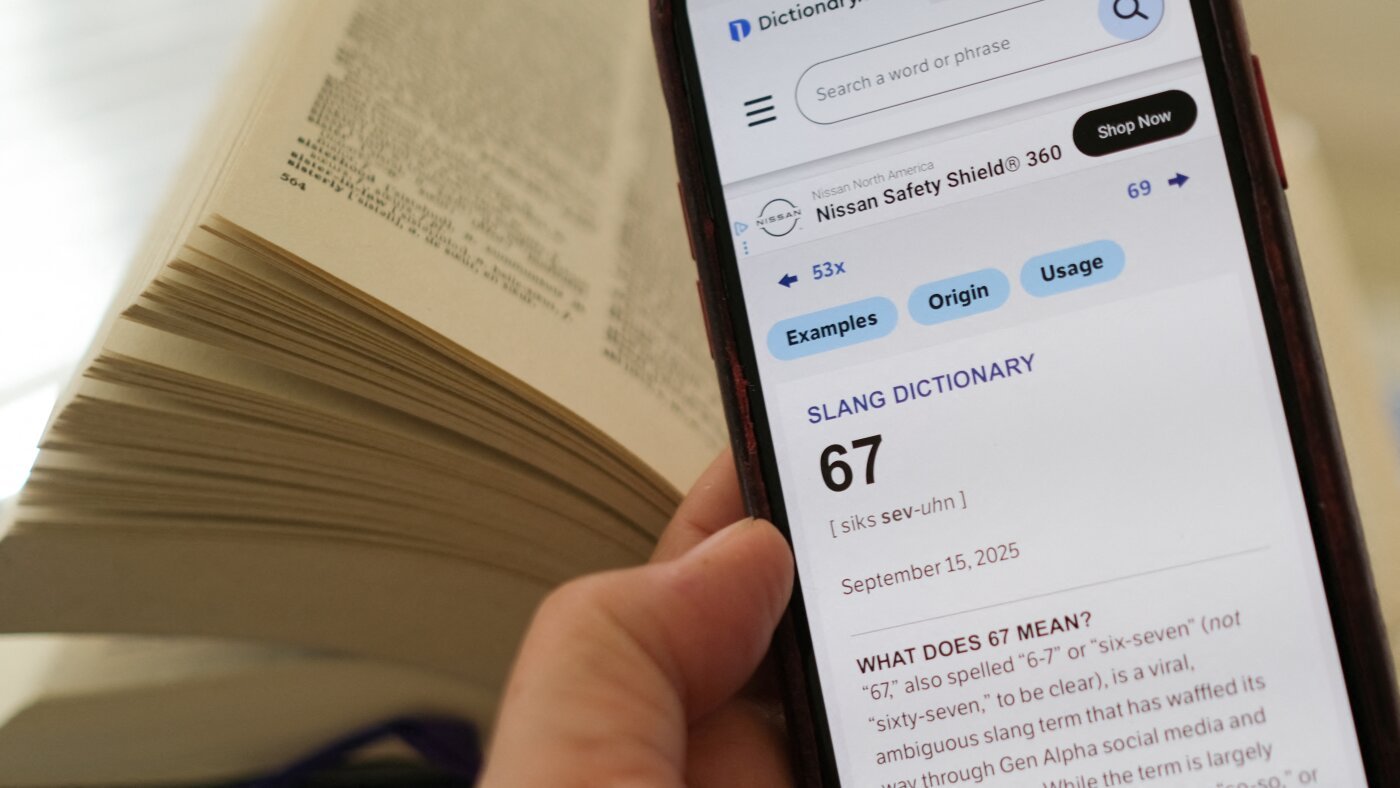 A smartphone showing the Dictionary.com entry for 67 beside an open printed dictionary
