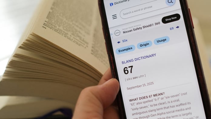 A smartphone showing the Dictionary.com entry for 67 beside an open printed dictionary