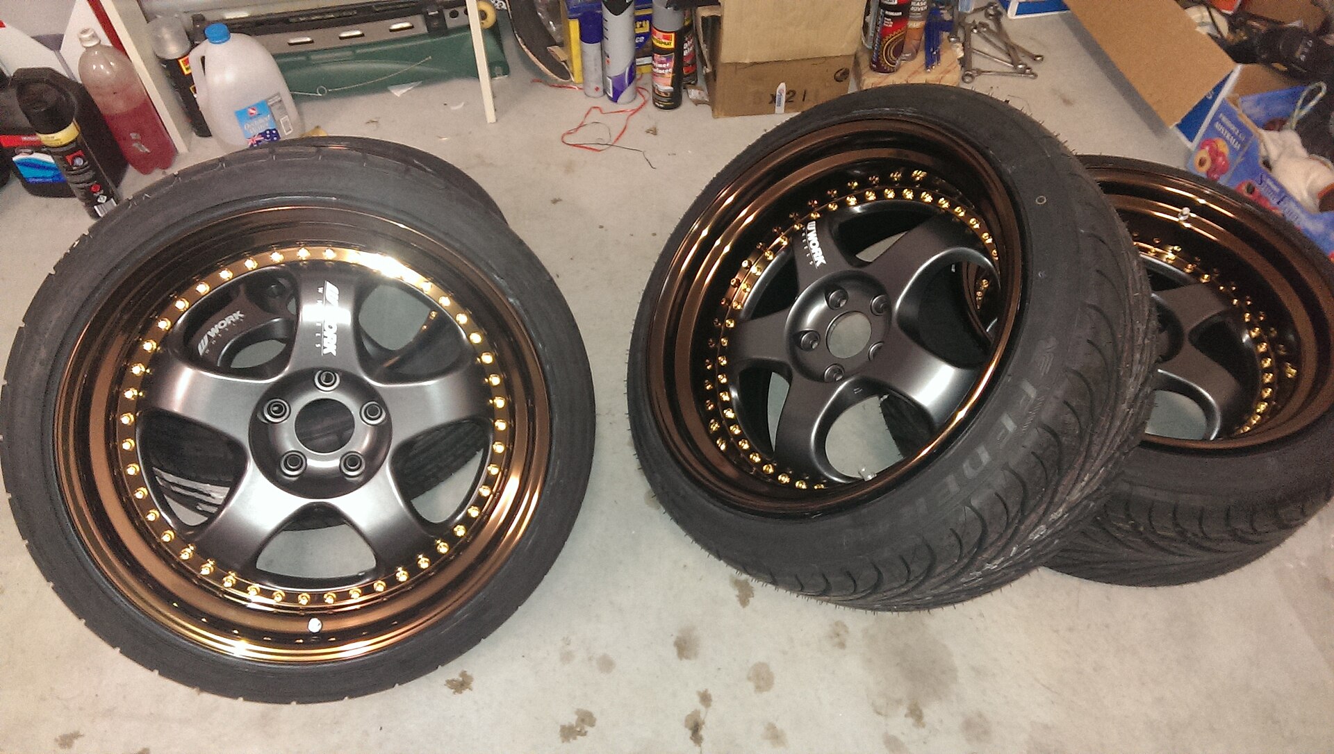 A Work Meister S1 three-piece forged wheel with an anodised bronze lip, gunmetal centre and gold rivets