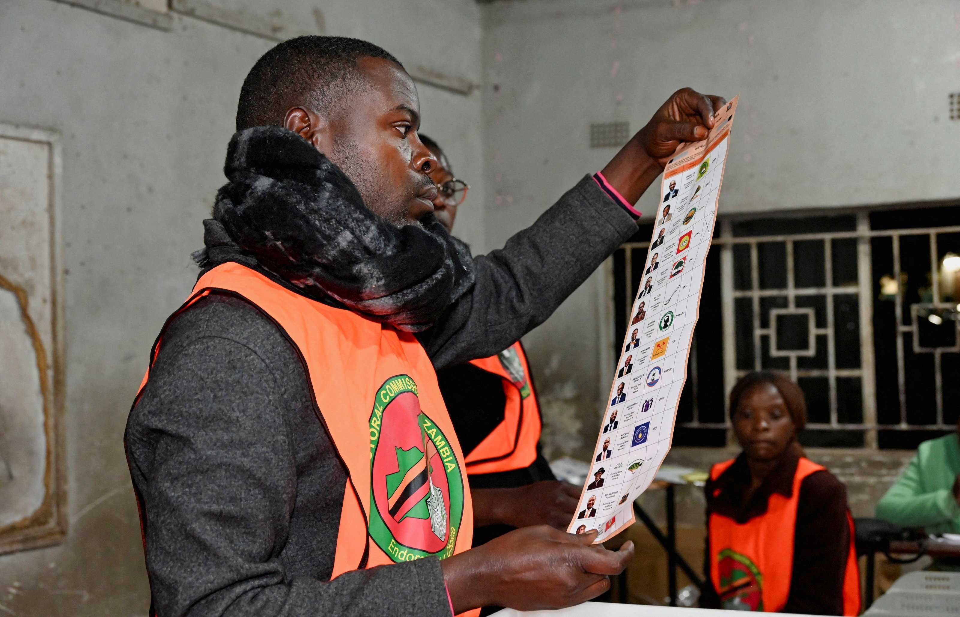 Election officials display and sort ballot papers during vote counting in Lusaka, Zambia, August 2026