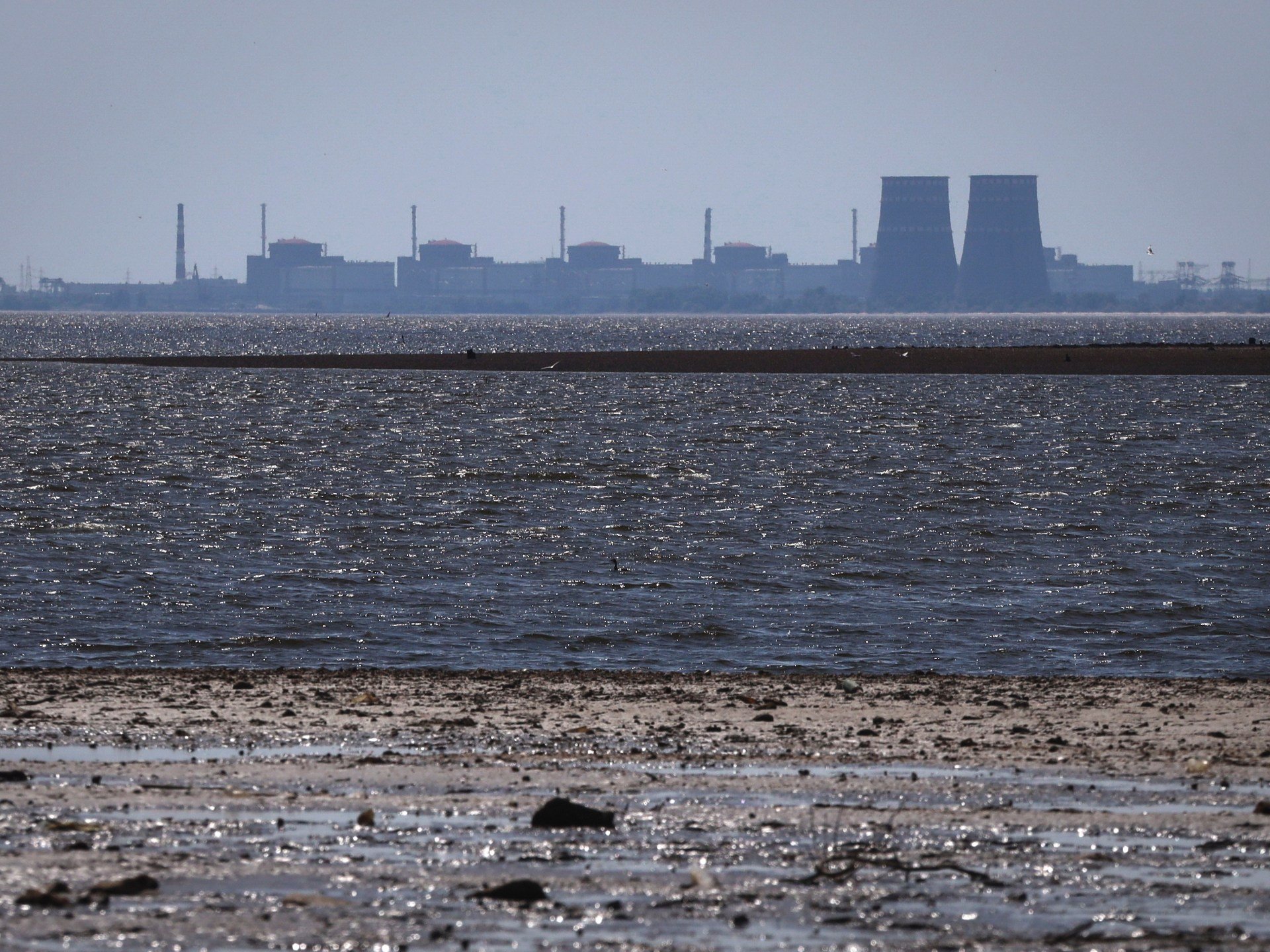 The six reactor buildings and cooling towers of the Zaporizhzhia Nuclear Power Plant seen on the horizon across the Dnipro River from the northern bank