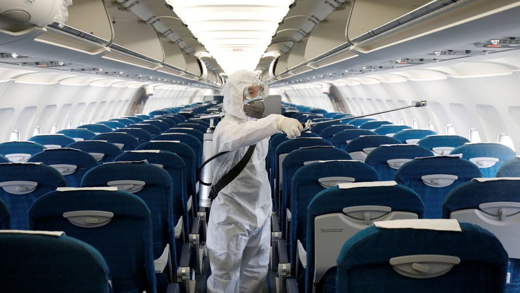 Health worker in protective gear disinfecting a Vietnam Airlines aircraft at Noi Bai airport in Hanoi during the coronavirus outbreak