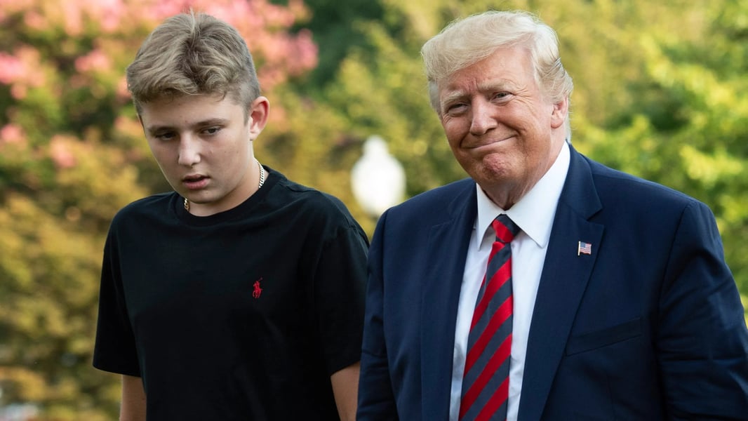 Barron Trump towering above his father President Donald Trump, showcasing his reported 6-foot-7 to 6-foot-9 height at a 2024 campaign rally