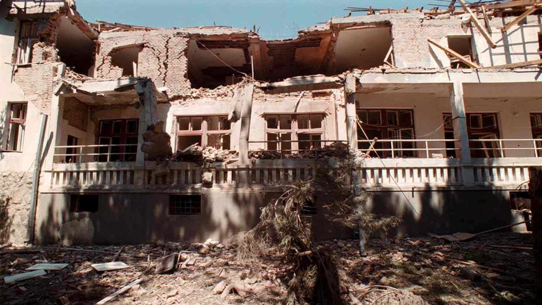 A local resident tries to recover belongings in the ruins of his home damaged by a NATO strike