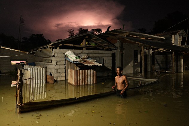 A resident wades through a flooded street caused by heavy rains from typhoon, northern Philippines