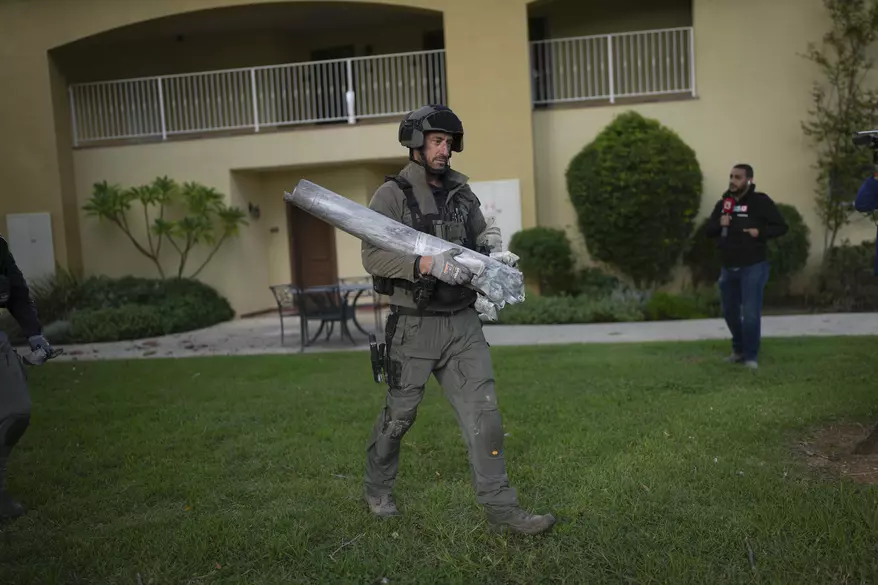 An Israeli bomb squad policeman carries the remains of a rocket