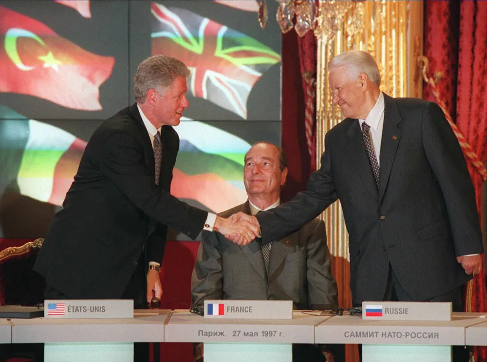 Bill Clinton shakes hands with his Boris Yeltsin as Jacques Chirac looks on, during the signing ceremony of the NATO-Russia Founding Act in Paris