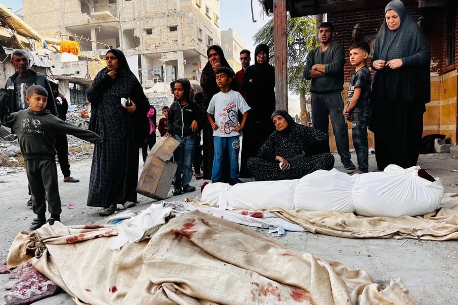 Palestinians mourn over the bodies of relatives after the Israeli military bombed a residential building in Beit Lahiya, Gaza