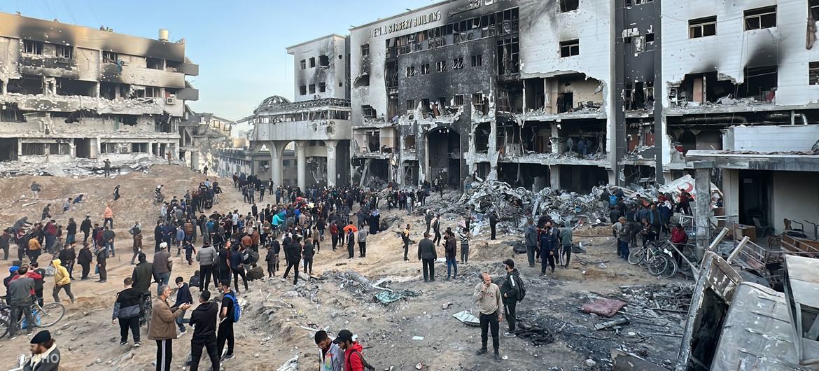People gather outside the remains of Al-Shifa Hospital, Gaza's largest health facility