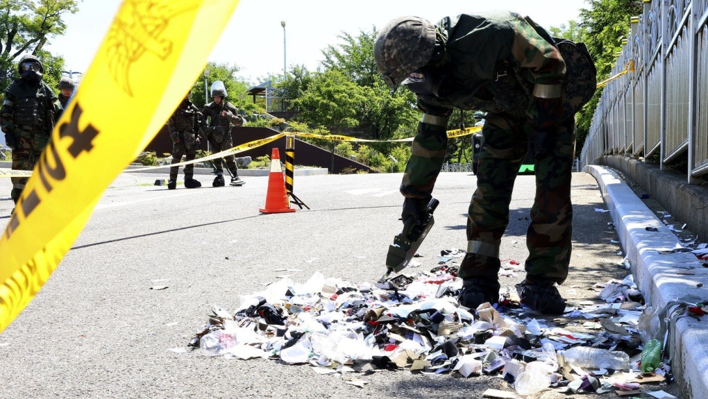South Korean soldier wearing protective gears checks trash from a balloon likely sent by North Korea