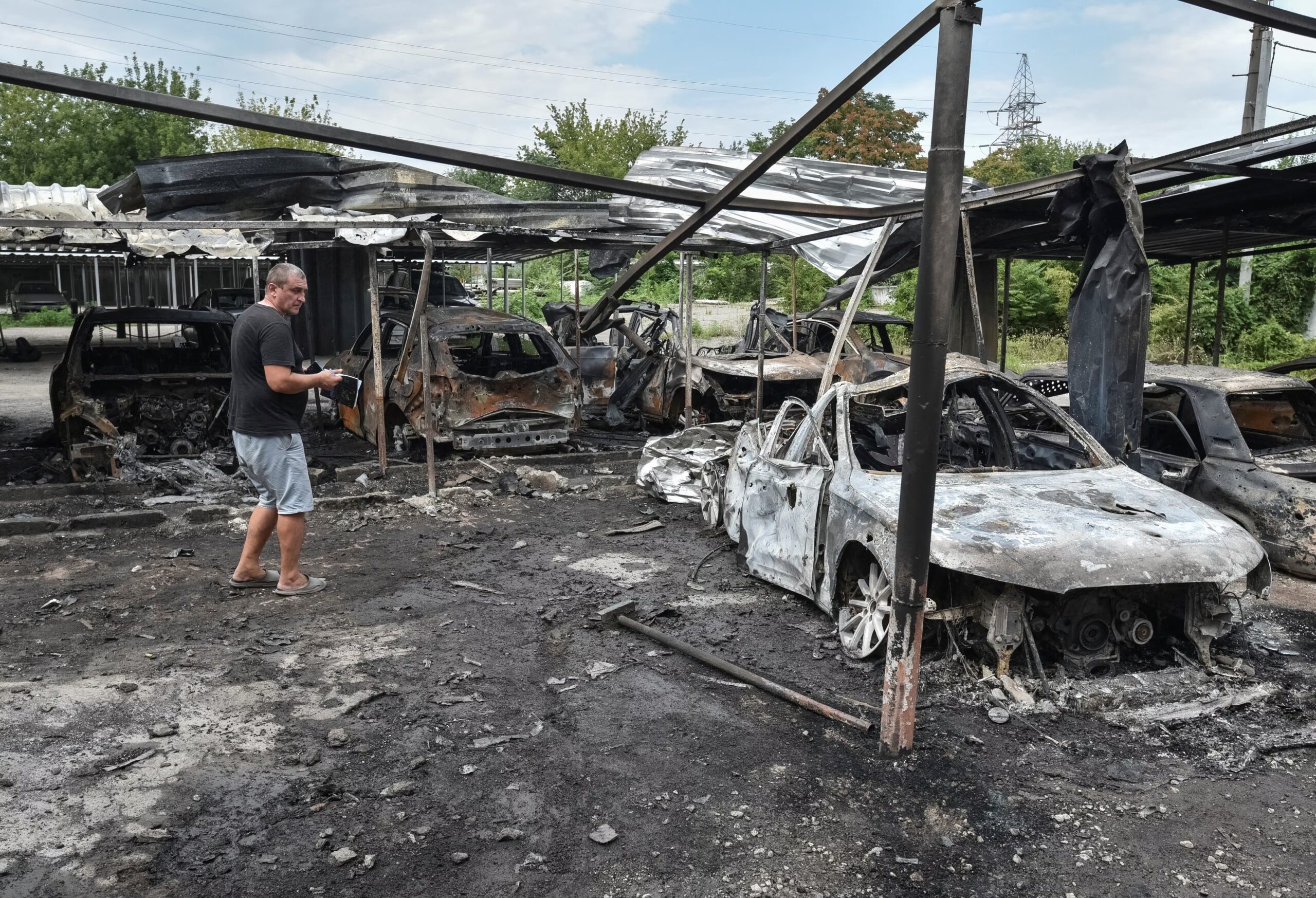 Resident, burned cars, Russian drone strike, Dnipro, Ukraine, July 26 2025, war damage, conflict zone