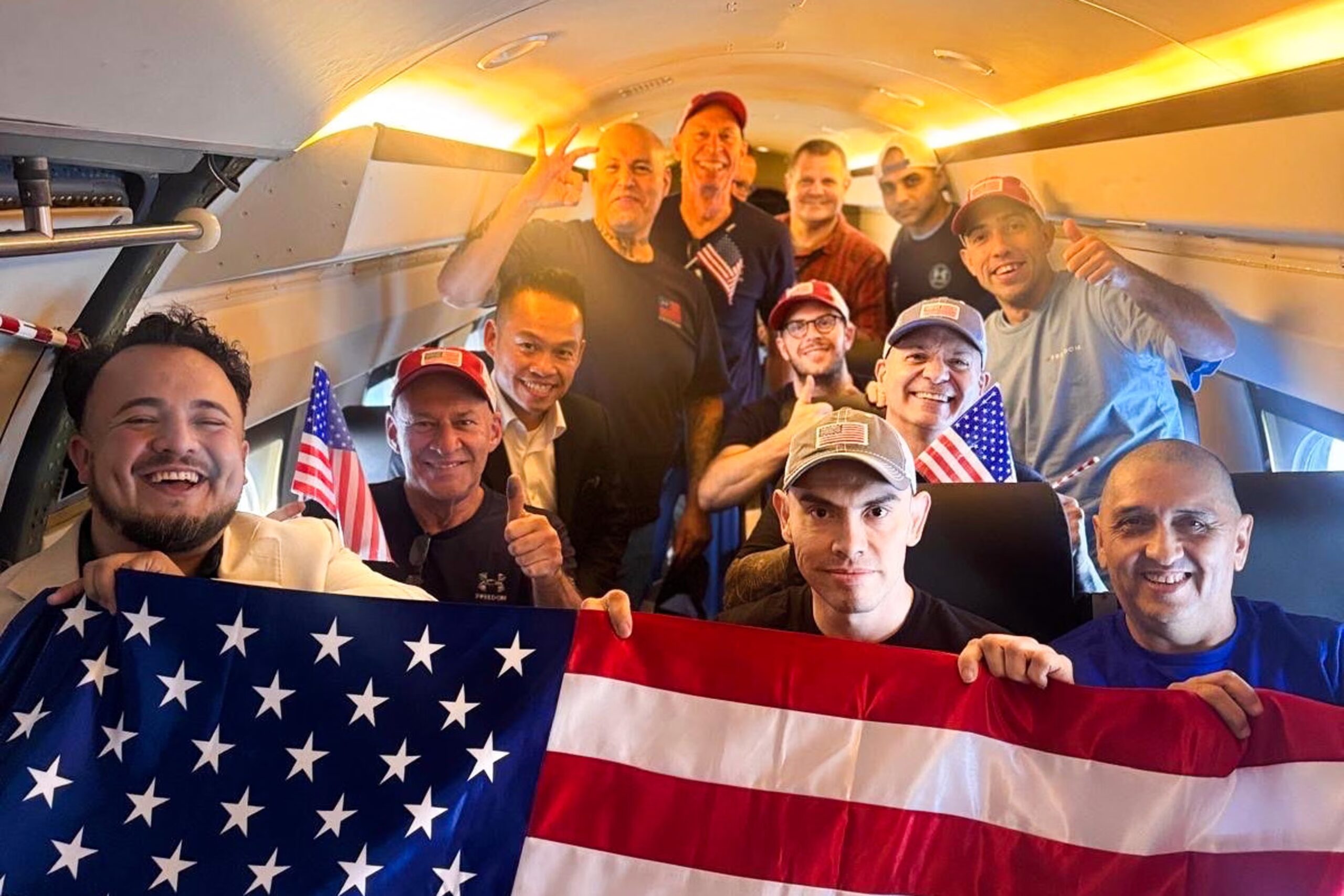 Dahud Hanid Ortiz holding a small U.S. flag after release, standing among other freed American detainees, photographed at a Texas airfield by the US Department of State via X.