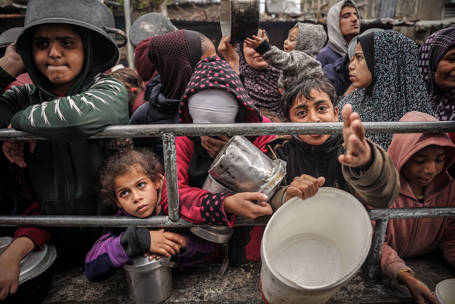 Gaza children and civilians stand in long lines for scarce food aid amid famine and genocide in Gaza.