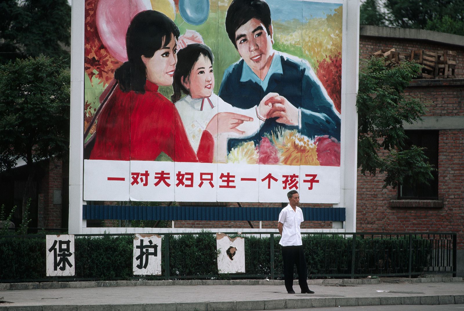 Young Chinese workers in Beijing ignoring government baby bonus poster