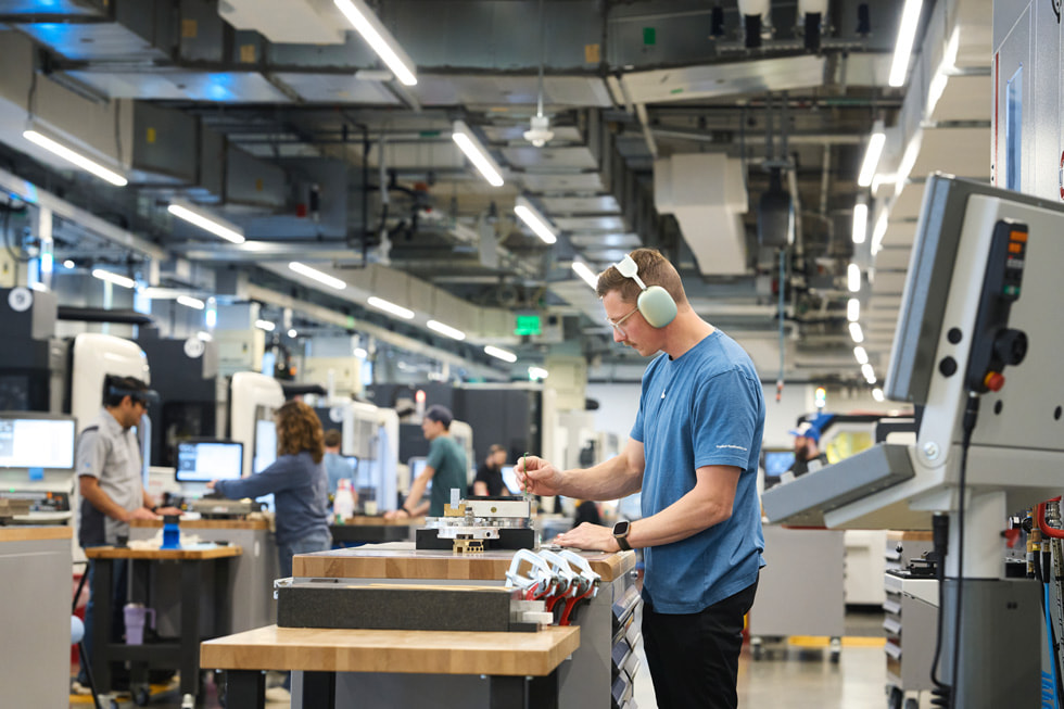 Apple worker in US manufacturing plant, representing $100 billion reshoring investment