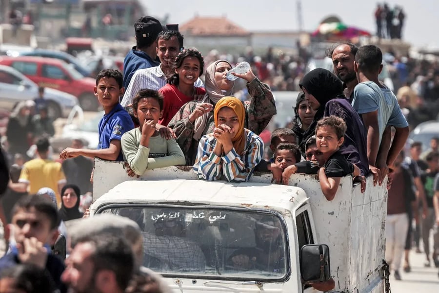 Displaced Palestinians carry belongings on Gaza’s coastal road