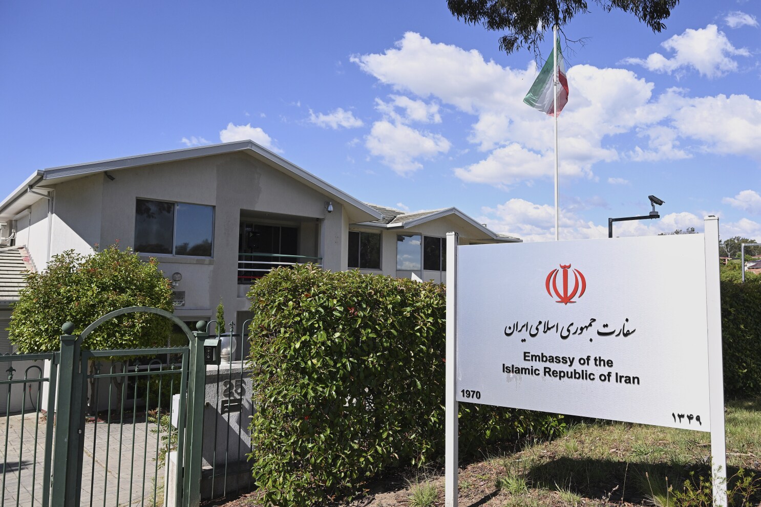 Exterior of Iran’s Foreign Ministry building with Iranian flag, paired with Australia’s Parliament House in Canberra.
