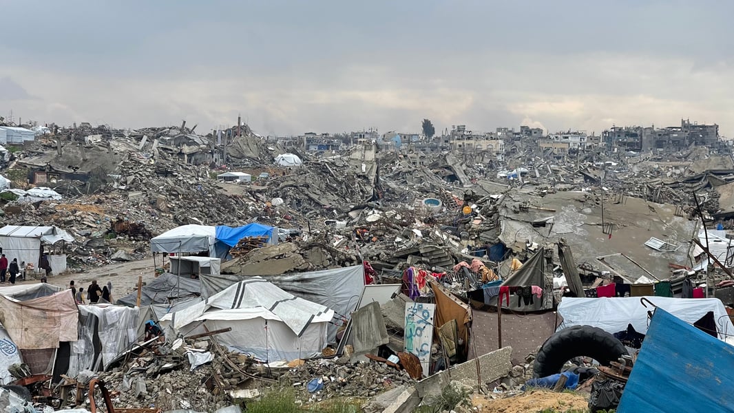 Gaza Destruction And Aid Lines Destroyed buildings in Gaza with civilians queuing for aid amid worsening hunger