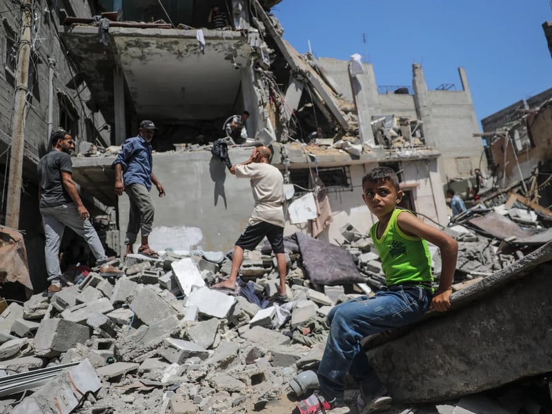 Rescuers climb rebar and concrete slabs after a tower collapse in Gaza City