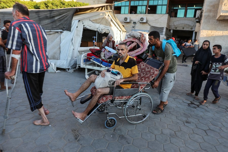 Displaced families push strollers and wheelchairs through a packed evacuation corridor in Gaza City
