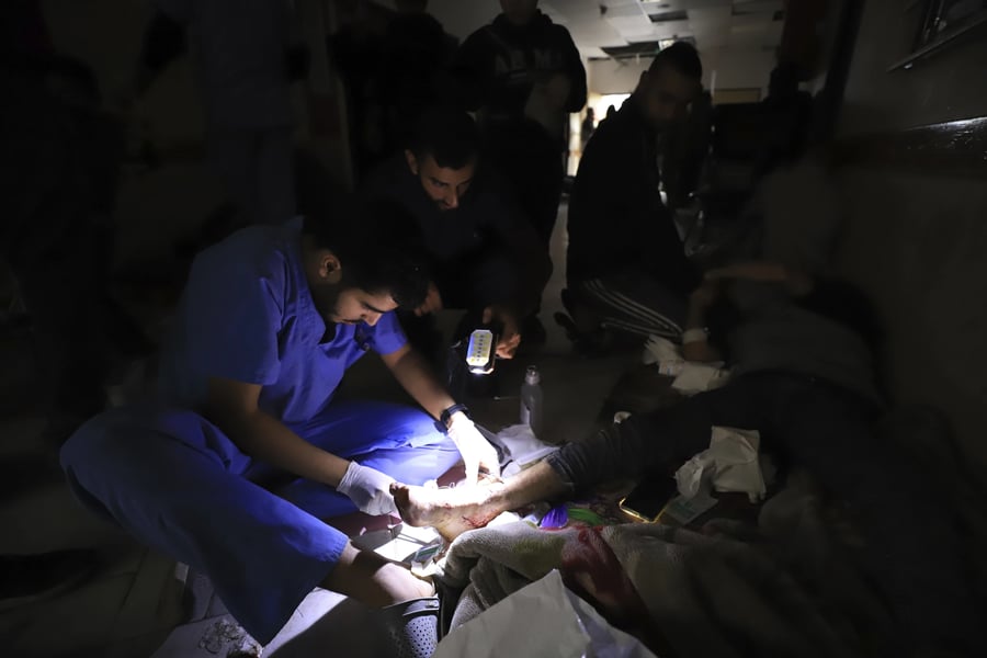 Nurses work by flashlight in a Gaza hospital corridor amid power cuts and fuel shortages