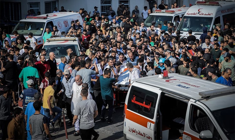 Medical staff triage patients in a crowded hospital corridor in Gaza City amid power cuts and supply shortages.