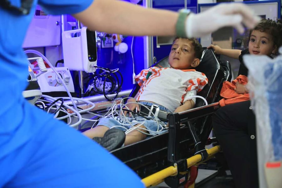 Families wait with children in a crowded pediatric oncology ward in Gaza City