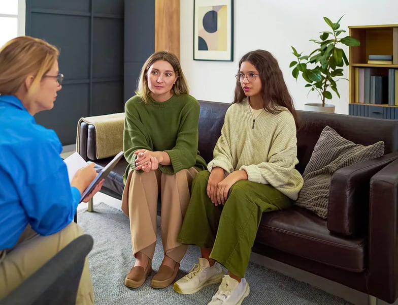 Young employee listening quietly during a stand-up meeting, “Gen Z stare”