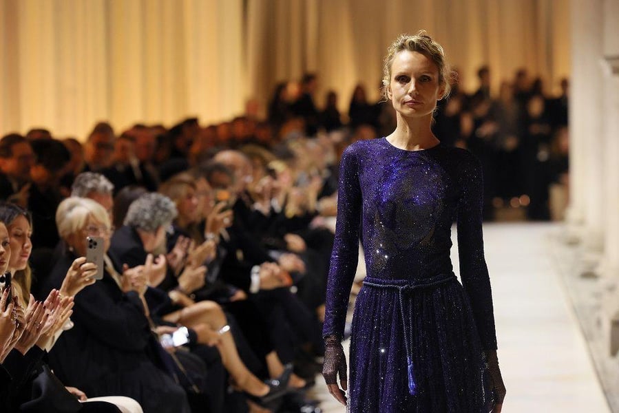 Models walk in Giorgio Armani’s final show at the Pinacoteca di Brera courtyard in Milan under lantern light.