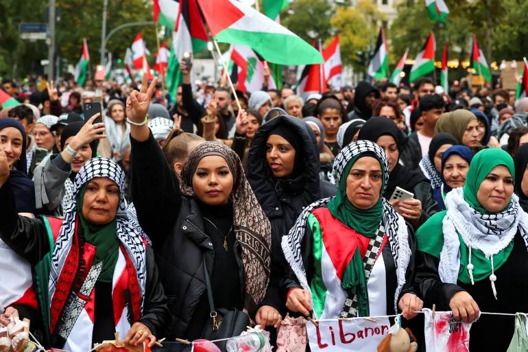 Protesters near UN headquarters in New York holding placards calling for a ceasefire and sanctions.