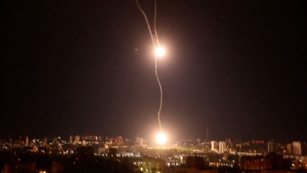 Kyiv skyline at night with air-defense intercepts streaking above the Dnipro River on day 1,314 of the Russia-Ukraine war
