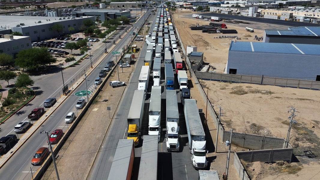 Trucks queue at the US-Mexico World Trade Bridge as a 25 percent tariff on heavy truck imports starts October 1