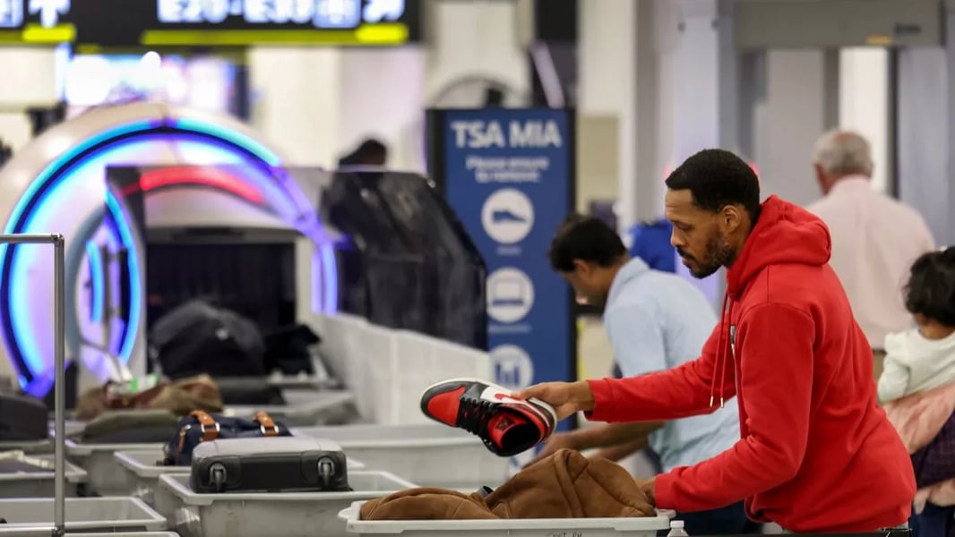 Airline passengers queue at TSA security as a shutdown looms