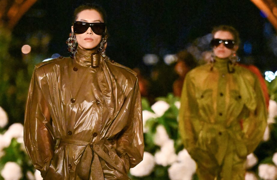 Saint Laurent Spring 2026 at Trocadéro with Eiffel Tower backdrop; model in nylon trench-dress on reflective runway