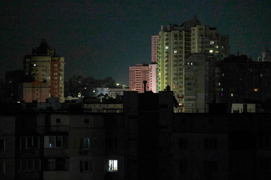 Resident uses phone light during a power outage in Kyiv as grid cuts hit the capital.