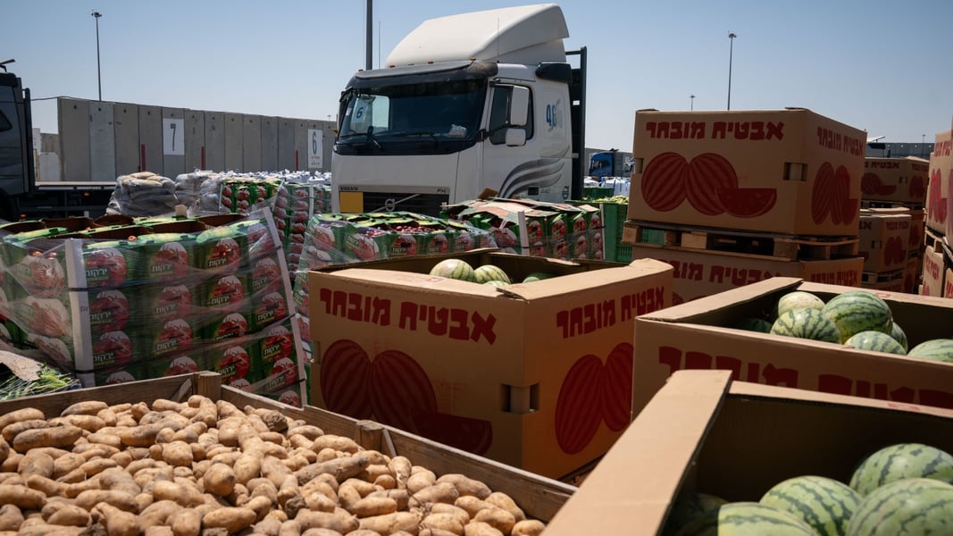 Covered trailers with relief supplies enter Gaza after a limited ceasefire as rubble lines the roadside