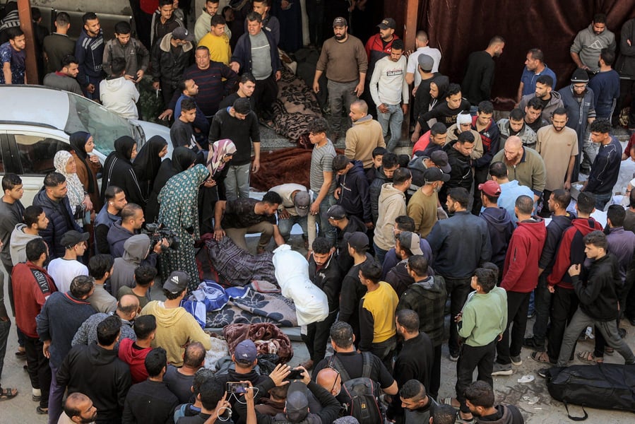 Civilian foot traffic resumes as armed men and local police manage queues near a Gaza clinic during the ceasefire