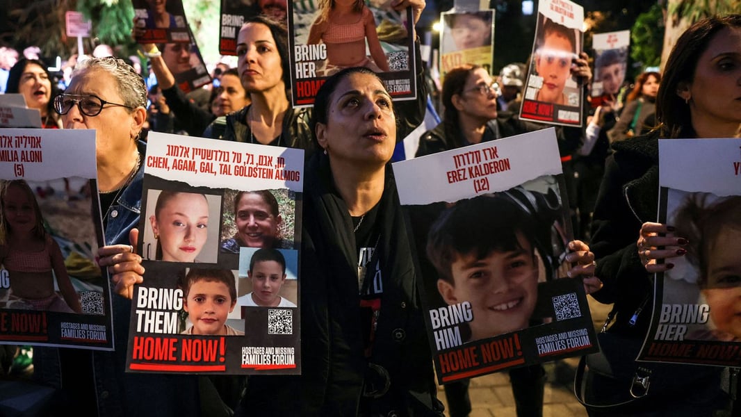 Families of Israeli hostages lift portraits during a rally at Tel Aviv’s central plaza