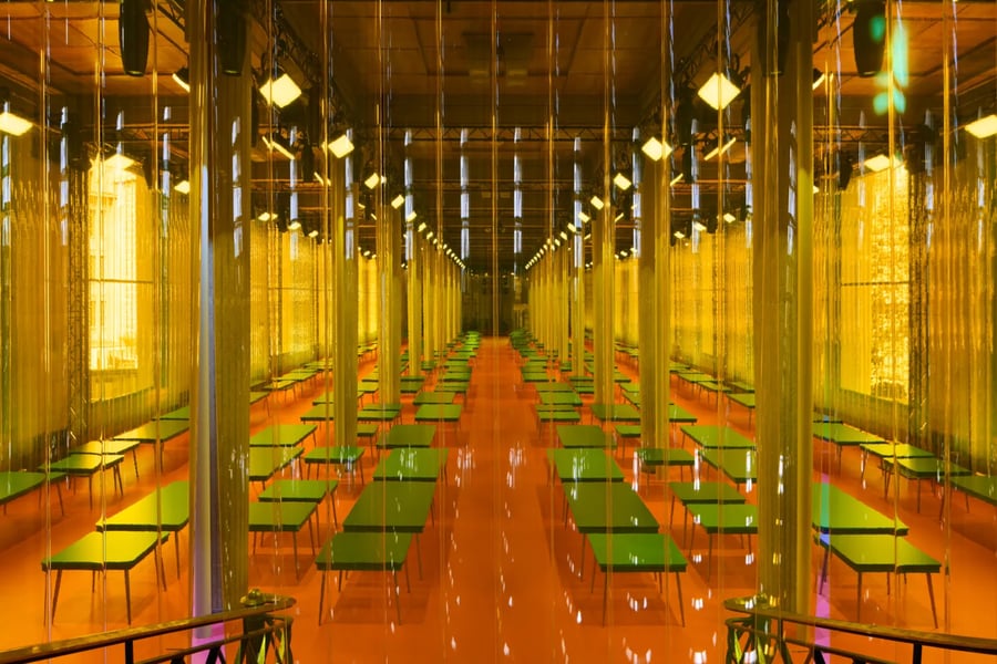 Inside Palais d’Iéna during Miu Miu Spring 2026 with tables across the show space